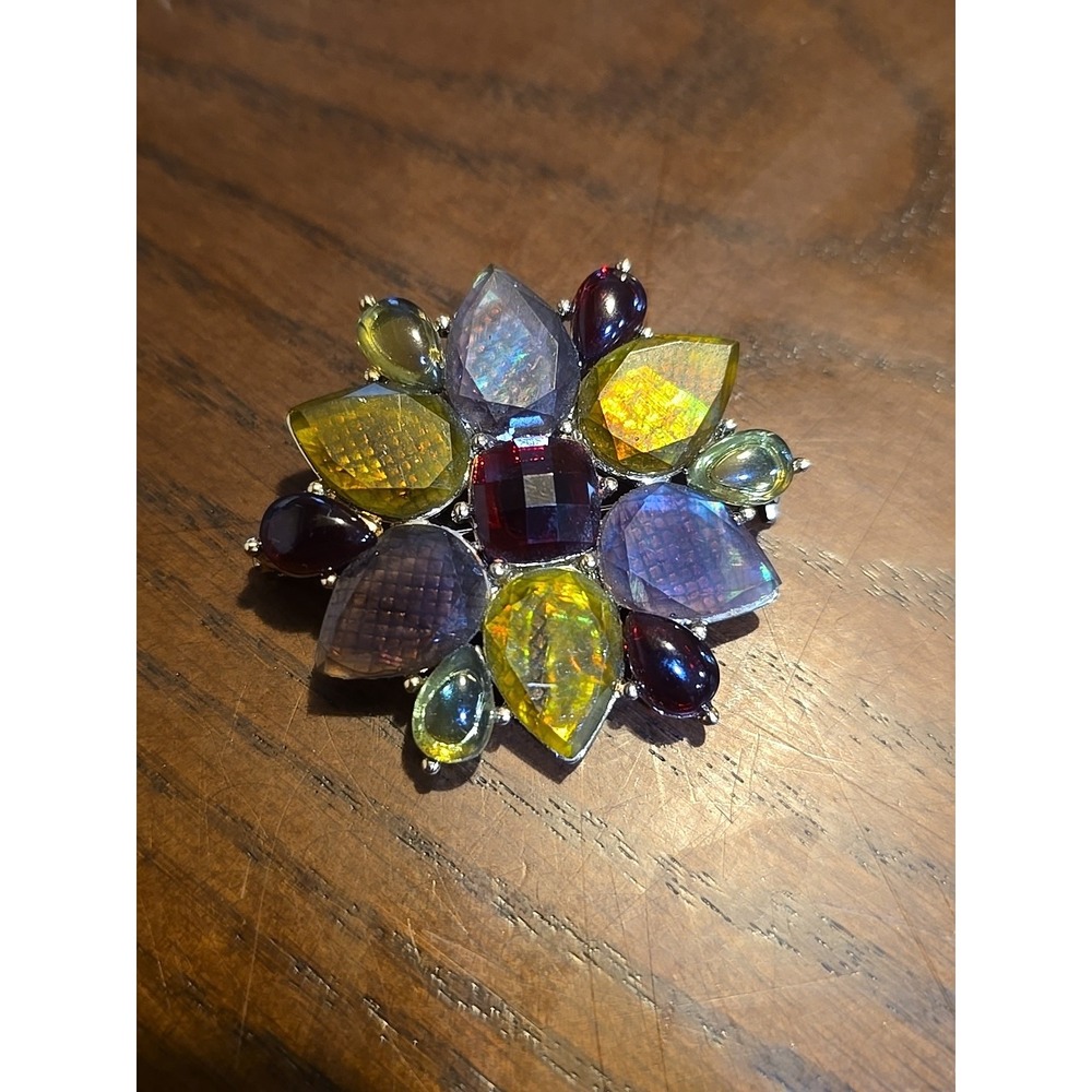 flower-shaped brooch featuring multiple colorful gemstones or glass stones. The